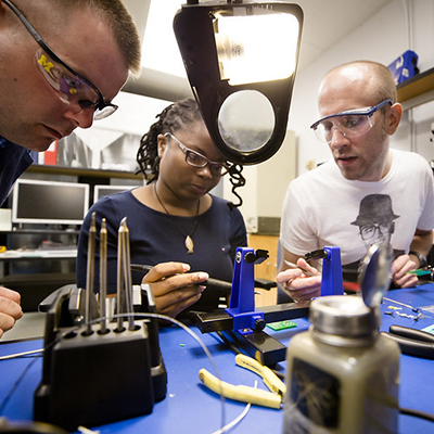 Photo of diverse students working with professor in a lab