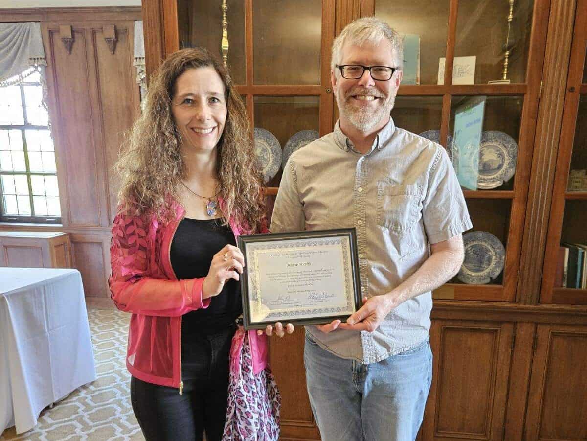 Photo of woman giving Aaron Ridley the award